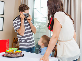 Image showing Man Taking Picture Of Family At Birthday Party