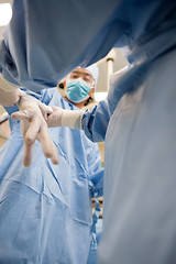 Image showing Female Nurse Assisting Doctor In Wearing Glove