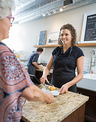 Image showing Cafe Owner Serving Sweet Food To Senior Woman