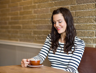 Image showing Attractive Woman Looking At Coffee Cup In Cafe