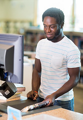 Image showing Librarian Working At Counter In Bookstore