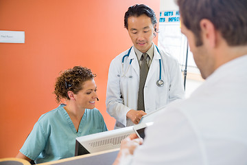 Image showing Medical Team Using Digital Tablet While Patient Standing At Rece