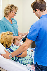 Image showing Nurse Explaining Reports On Tablet To Couple With Babygirl