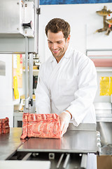 Image showing Butcher Slicing Meat On Bandsaw In Shop