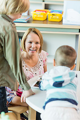 Image showing Cheerful Teacher With Children In Library