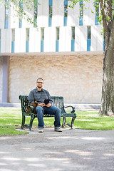 Image showing Mid Adult Student Sitting On Bench At Campus