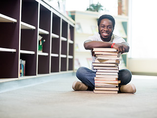 Image showing Happy Student Leaning On Stacked Books In Library