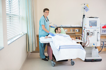 Image showing Nurse Standing By Patient Receiving Dialysis In Hospital