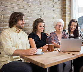 Image showing Woman With Friends Using Laptop At Cafe Table