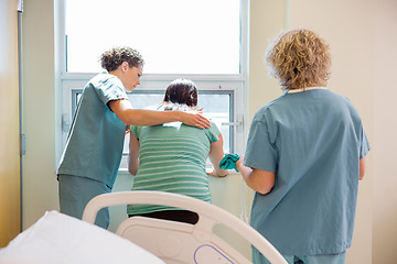 Image showing Nurse Carrying Hospital Gown For Worried Pregnant Woman