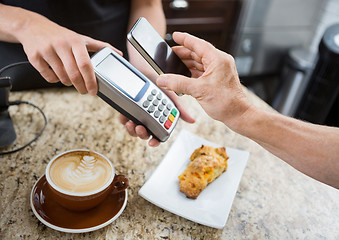 Image showing Customer Paying Through Mobilephone Over Electronic Reader At Ca