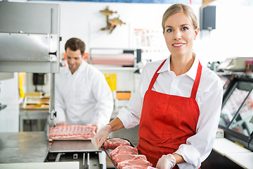 Image showing Smiling Butcher Holding Meat Tray At Store