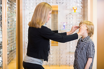 Image showing Woman Trying Spectacles On Son At Shop