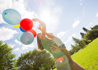 Image showing Mother And Daughter Holding Balloons In Park