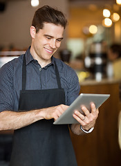 Image showing Male Owner Using Digital Tablet In Cafeteria