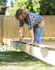 Image showing Worker Using Hammer On Wooden Frame At Construction Site