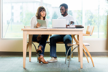 Image showing Friends Using Technologies While Studying In Library