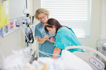 Image showing Pregnant Woman Breathing Through Oxygen Mask While Nurse Assisti