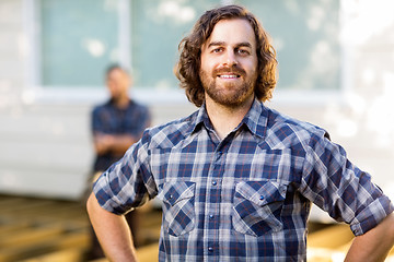 Image showing Manual Worker Smiling While Coworker Standing In Background