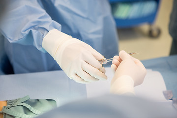 Image showing Surgeons Passing Surgical Scissors During Surgery