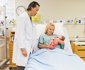 Image showing Mother And Doctor Looking At Newborn Baby Girl In Hospital