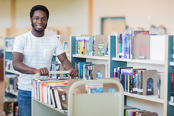 Image showing Librarian With Trolley Of Books In Bookstore