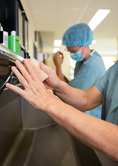 Image showing Surgeons Scrubbing Hands With Colleague