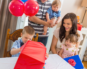 Image showing Family Looking At Birthday Boy Opening Gift Box