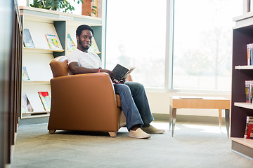 Image showing Young Student Reading Book In Library