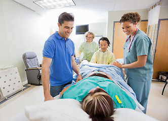 Image showing Happy Medical Team And Husband Looking At Pregnant Woman