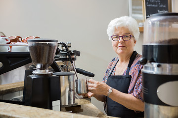 Image showing Senior Woman Steaming Milk with Espresso Machine