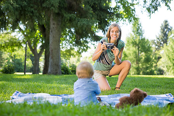 Image showing Mother Taking Picture Of Baby Boy In Park