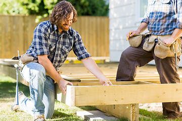 Image showing Workers Working On Wooden Frame At Construction Site