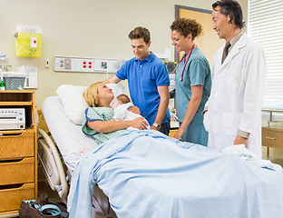 Image showing Medical Team And Man Looking At Mother With Babygirl