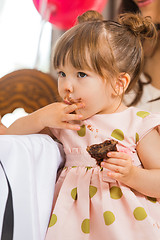 Image showing Cute Girl Eating Cake With Icing On Her Face