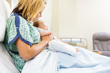 Image showing Woman Looking At Newborn Babygirl On Hospital Bed