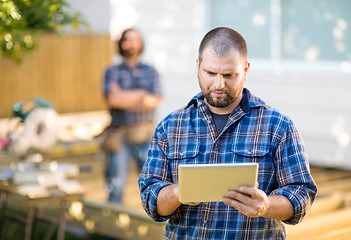 Image showing Manual Worker Using Digital Tablet With Coworker Standing In Bac