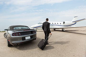 Image showing Businessman Standing By Car And Private Jet At Terminal