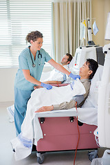 Image showing Nurse Covering Patient Undergoing Renal Dialysis With Blanket