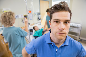 Image showing Worried Man With Nurses Examining Pregnant Woman In Hospital