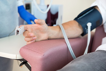 Image showing Oximeter Attached To Male Patient's Finger In Hospital