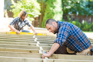 Image showing Carpenter Using Drill On Wood At Site