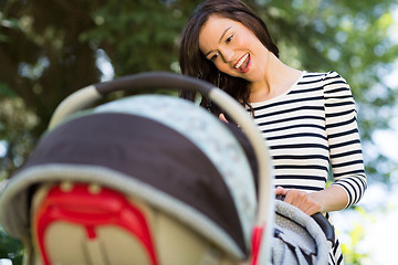 Image showing Woman Looking Into Baby Carriage In Park