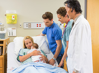 Image showing Medical Team And Man Looking At Mother With Babygirl