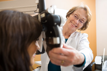 Image showing Happy Optometrist Adjusting Phoropter For Patient