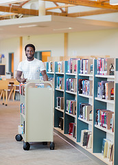 Image showing Librarian With Trolley Of Books In Bookstore