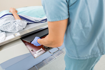 Image showing Male Nurse Adjusting Film In Xray Table