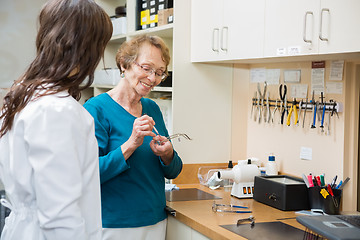 Image showing Optician With Female Apprentice Repairing Glasses