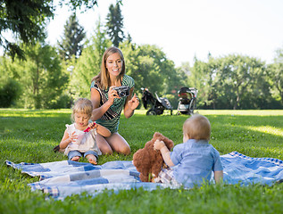 Image showing Mother Photographing Children In Park