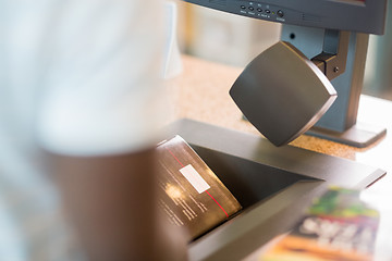 Image showing Librarian Scanning Books At Library Counter